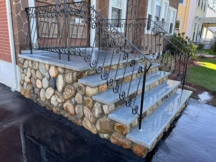 Stone wall with integrated granite steps in a salt-and-pepper finish